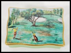An antique porcelain box decorated with golfing scenes having pained notation to interior reading RW