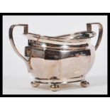 An early 20th Century hallmarked silver sugar bowl by Atkin Brothers raised on four bun feet with