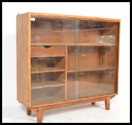 An early 20th century golden oak and glass display cabinet having sliding glass doors and an
