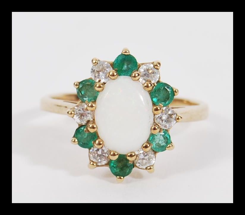A vintage 20th Century hallmarked 9ct gold ring having a central opal panel with a halo of green and