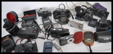 A collection of film and digital cameras to include a Canon Power Shot IS, Cosina PM-1, Yashica 35-