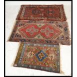A group of three Persian Islamic 20th Century carpet rugs to include a runner having a red ground