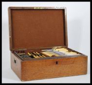 An early 20th Century oak cased canteen of cutlery, the hinged lid opening to reveal an extensive