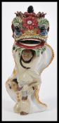 An unusual 20th Century Chinese pottery figurine depicting two figures in dragon costume raised on