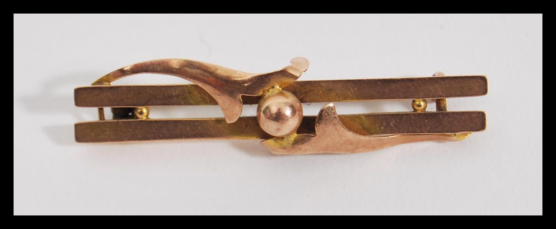 An early 20th Century hallmarked 9ct gold bar brooch having a double bar with central ball and