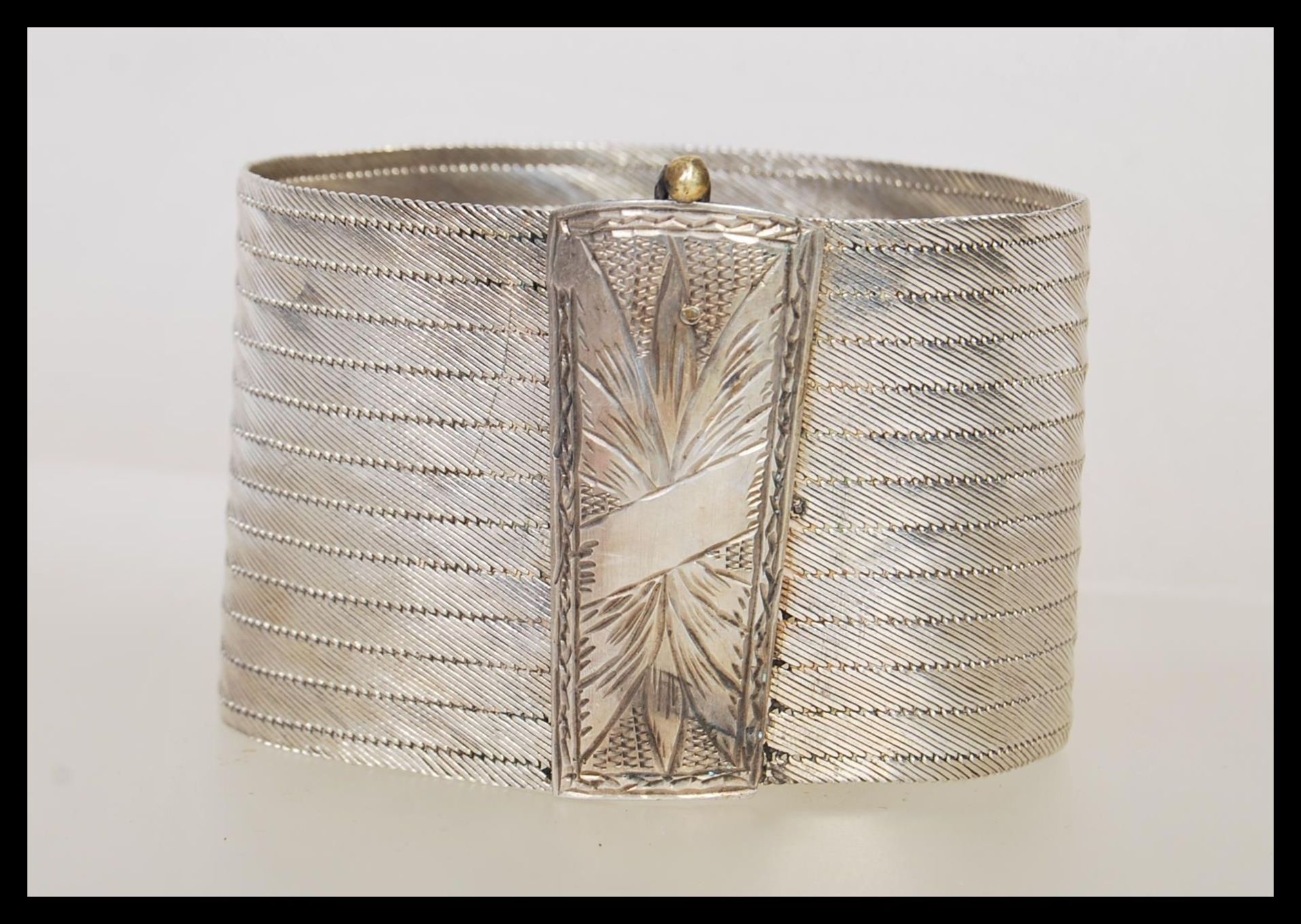A stamped 900 silver ethnic style bangle bracelet having a rectangular clasp to the front with