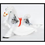 A vintage retro 20th Century ceramic carousel rocking horse figure ornament having a white ground