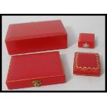 A collection of four vintage 20th Century red leather Cartier jewellery boxes of varying sizes.