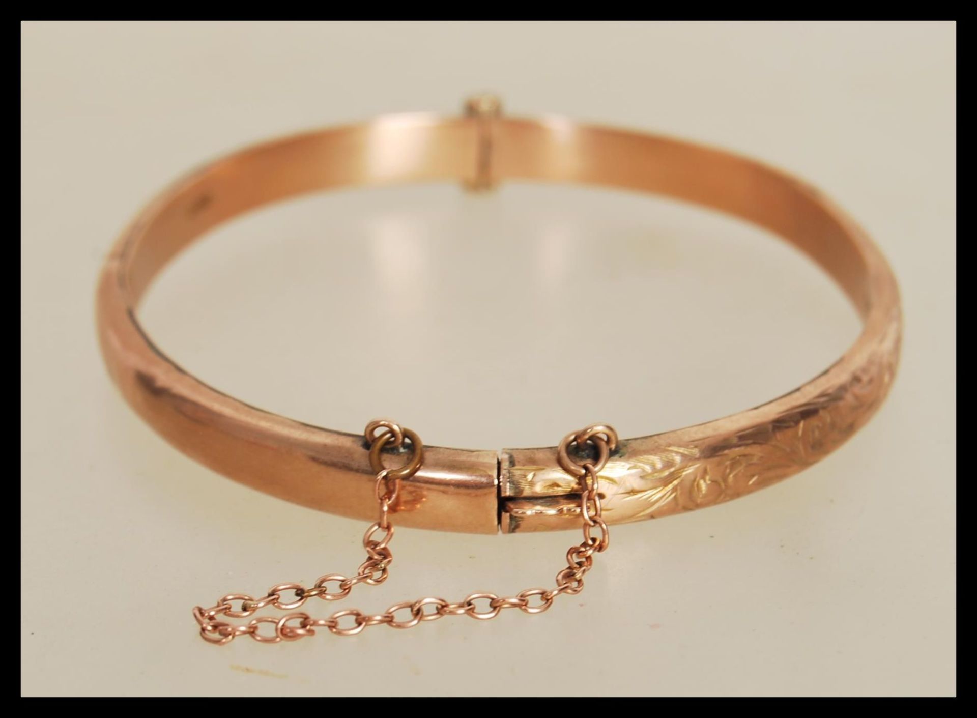 A hallmarked 9ct gold bangle bracelet with engraved floral decoration to front, having hinged - Bild 2 aus 4