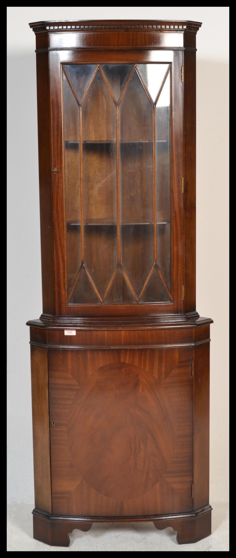 A 1930's walnut demi-lune china display cabinet having stained glass upper sections with lozenge