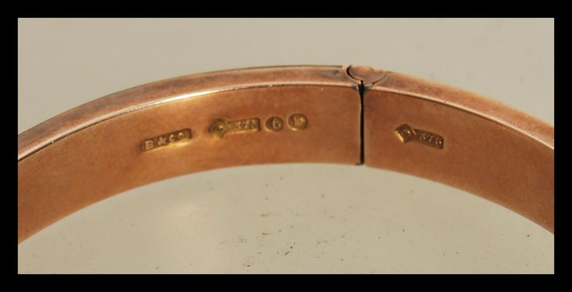 A hallmarked 9ct gold bangle having a hinged opening and safety chain. Hallmarked London 1914. - Bild 3 aus 4