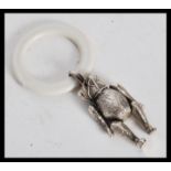 A sterling silver babies teething ring figurine in the form of a bear having articulated legs and