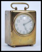 An early 20th Century brass / bronze cased desk travel carriage clock having a white enamel face