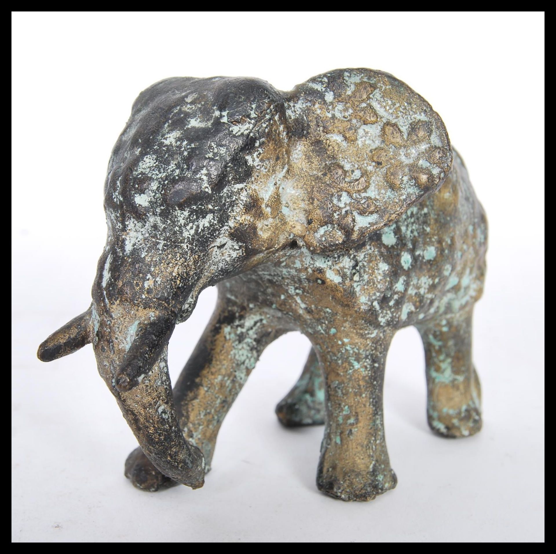 A 19th Century bronze figurine in the form of a Bull Elephant with tusks in full run, having