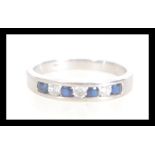 A hallmarked 9ct white gold seven stone diamond and sapphire ring having alternating blue and