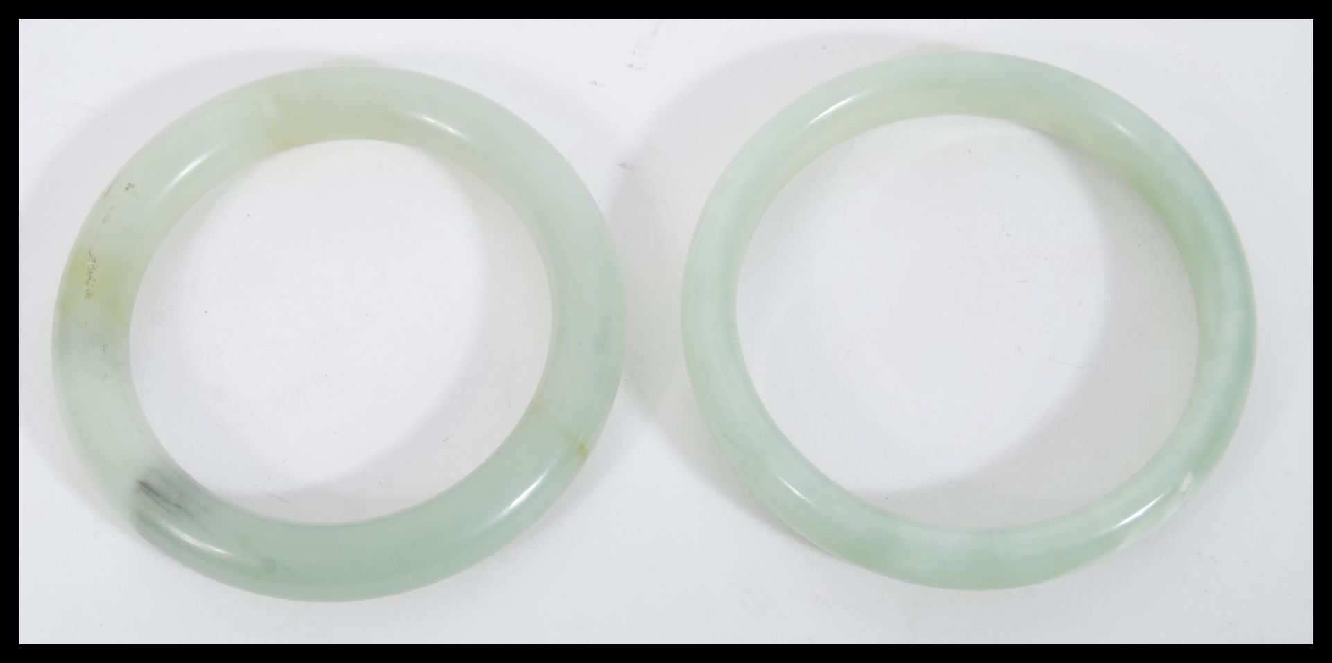 A pair of Chinese jade bangle bracelets of circular form. Measures 8.5 cm diameter.