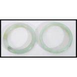 A pair of Chinese jade bangle bracelets of circular form. Measures 8.5 cm diameter.