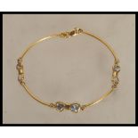 A stamped 750 18ct gold spacer bracelet set with six white stones, having a lobster clasp. Weight