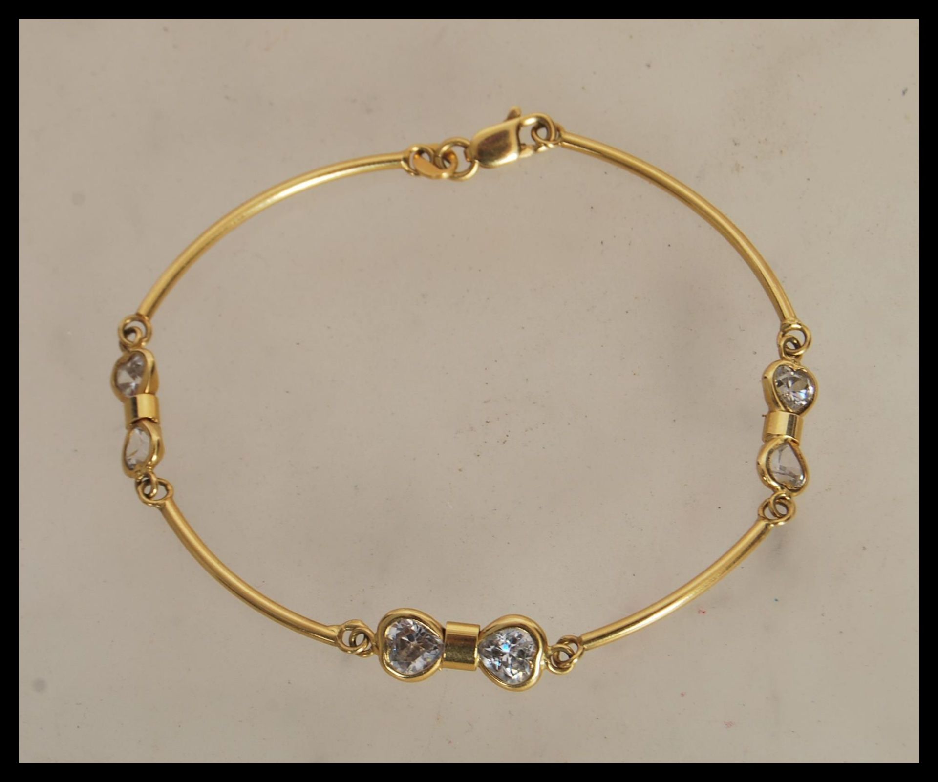 A stamped 750 18ct gold spacer bracelet set with six white stones, having a lobster clasp. Weight