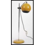 A vintage retro 20th Century Eyeball desk lamp raised on circular base with adjustable tubular