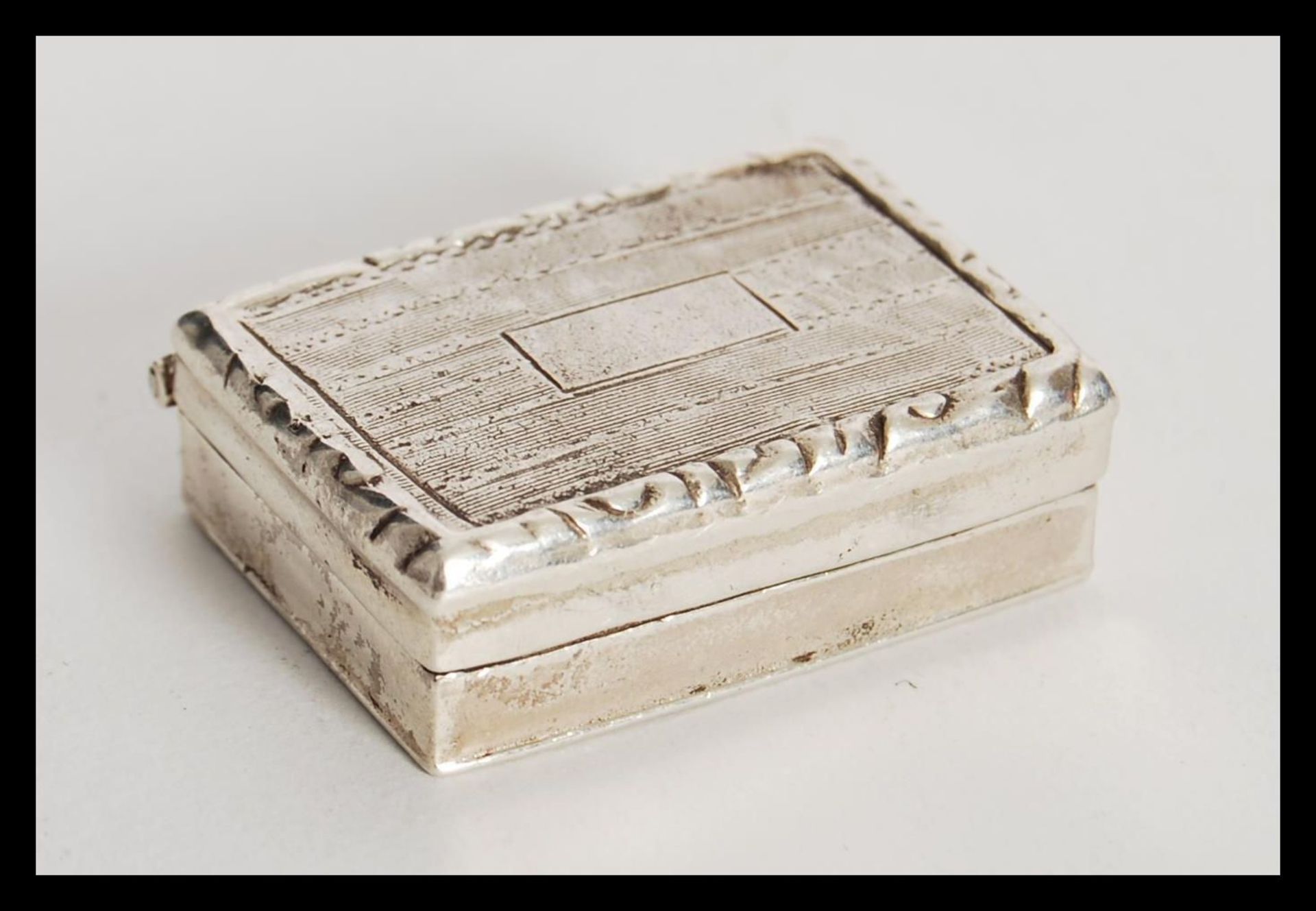 An unmarked silver tests as silver vinaigrette of rectangular form having hinged lid revealing