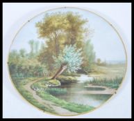 A 20th century hand painted wall charger plate, possibly by Limoges, having a hand painted landscape