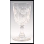 A large 19th Century faceted glass wine glass of tall form raised on a circular foot with faceted