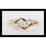 A stamped 18ct gold crossover ring millegrain set with three diamonds. Weight 2.3g. Estimated