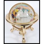 A vintage 20th Century desk top globe having a gilt brass frame with semi precious lapis lazuli