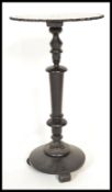 A Victorian 19th century ebonised side table having a round top and base