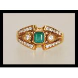 A stamped 750 18ct gold ladies dress ring set with a square cut emerald within a split shank