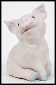 A large vintage 20th Century chalk / ceramic figurine of a pig modelled in a seated position.