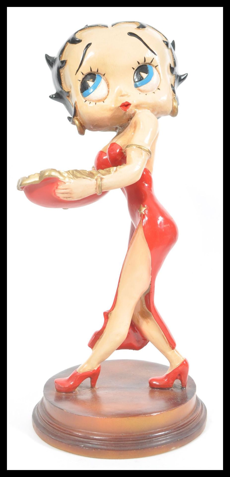 A large figure of Betty Boop raised on circular wooden base. The iconic character in red dress.