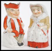 A pair of 19th Century Staffordshire pottery Toby jugs modelled as Mr Punch and Judy. Measures