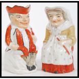 A pair of 19th Century Staffordshire pottery Toby jugs modelled as Mr Punch and Judy. Measures