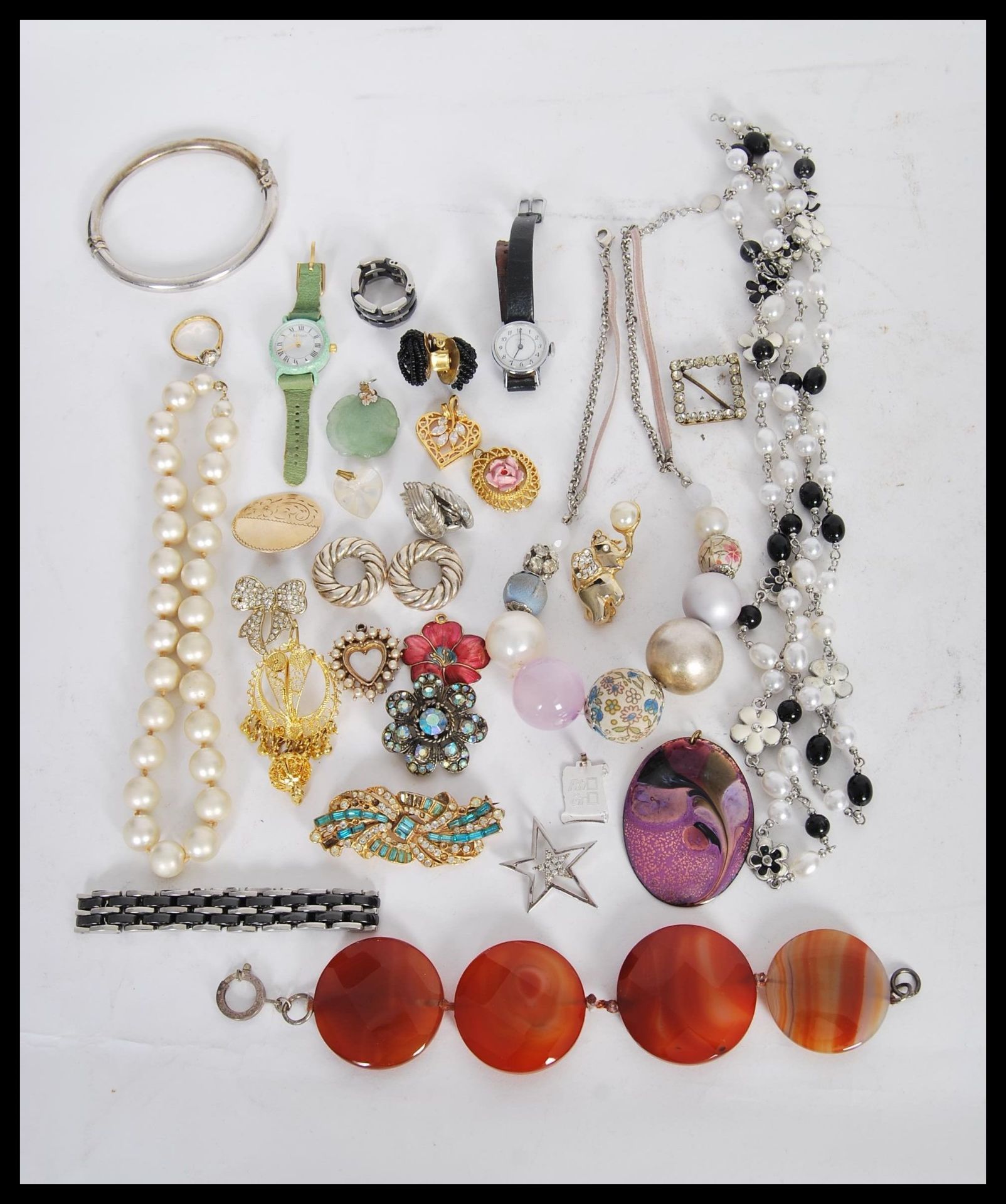 A collection of vintage costume jewellery to include a silver hinged bangle, a bracelet of four