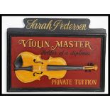 A vintage style advertising wall plaque advertising a Violin Master Private Tuition wooden sign