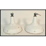 A pair of 1940's retro industrial factory ceiling pendant lights of saucer form having a white