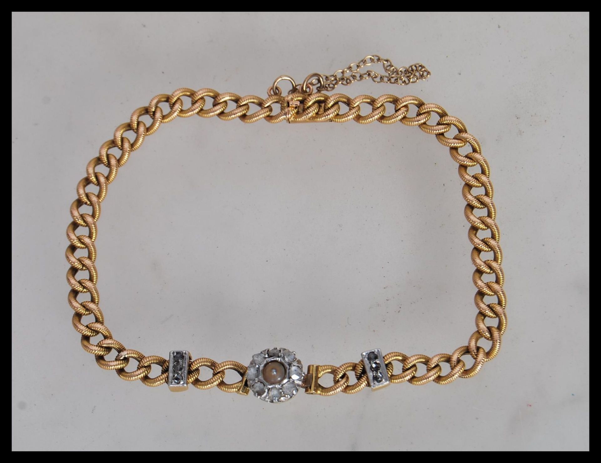 A 19th Century Victorian 18ct gold bracelet having a curb link chain with a central halo of old