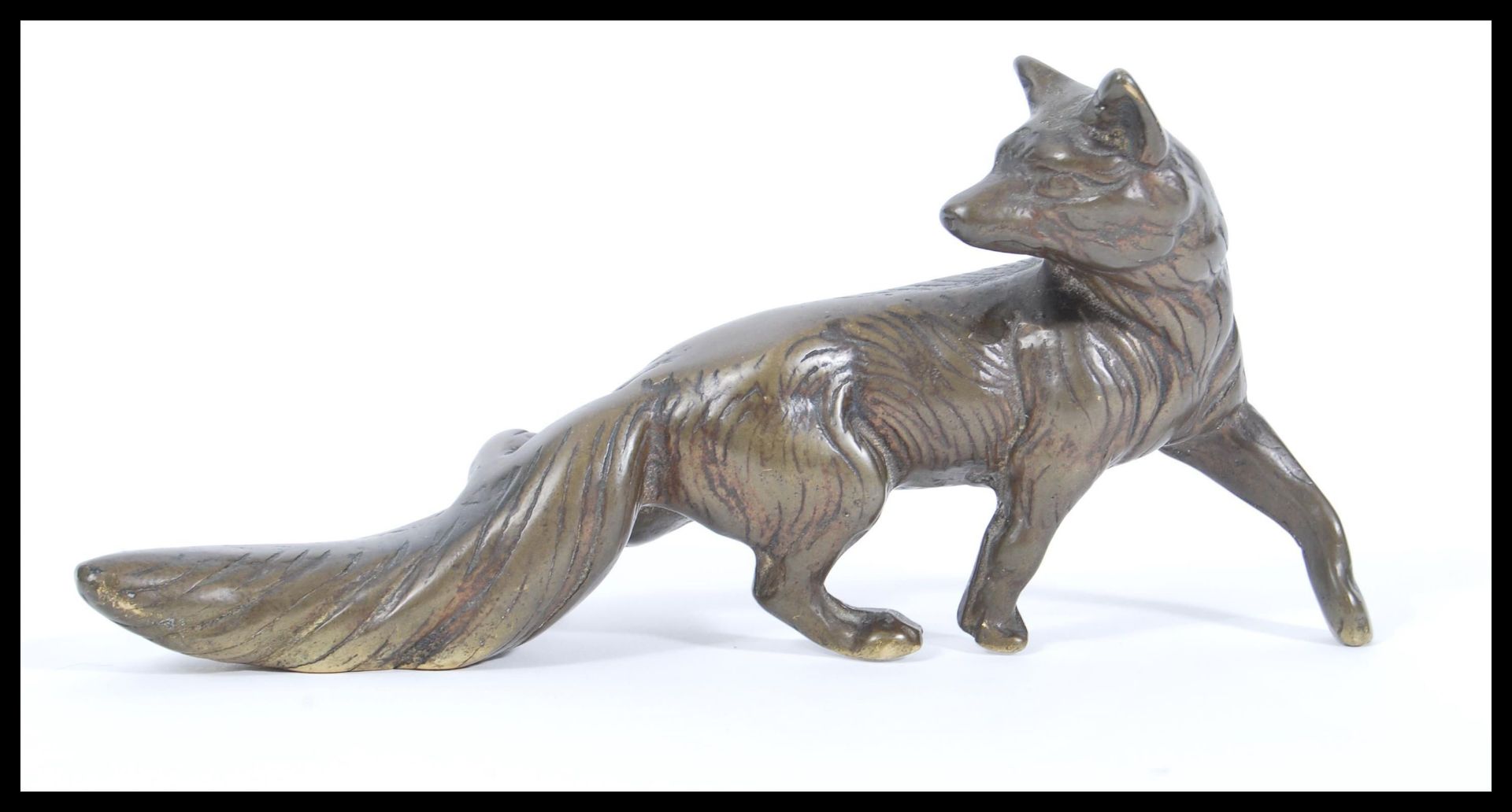 A 20th Century cast bronze figurine in the form of a stalking fox looking over its shoulder with