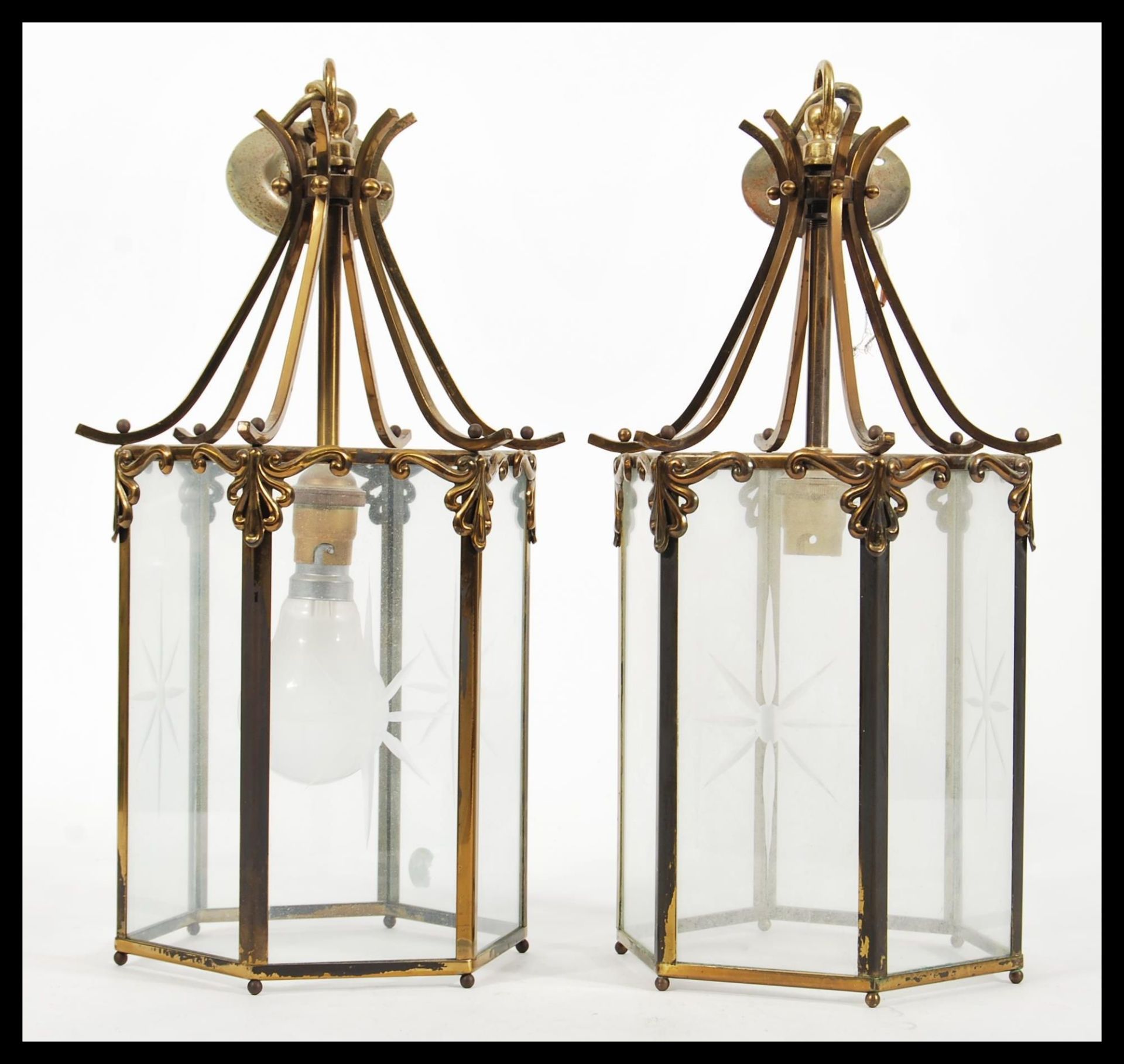 A pair of early 20th Century brass porch lantern of hexagonal form having glazed glass panels with