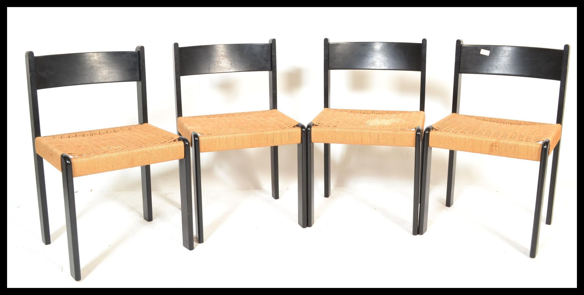 A set of four vintage retro 20th Century Danish dining chairs raised on ebonised beech frames with
