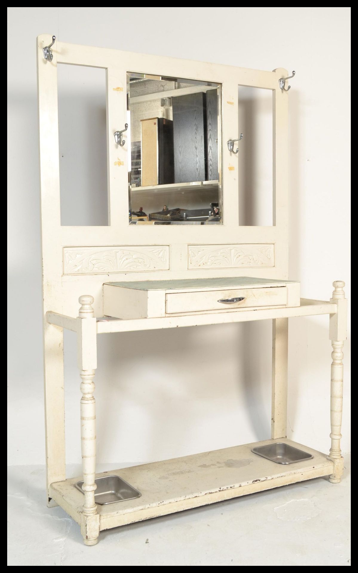 A 19th Century Victorian white painted hall stand raised on block and turned legs with carved