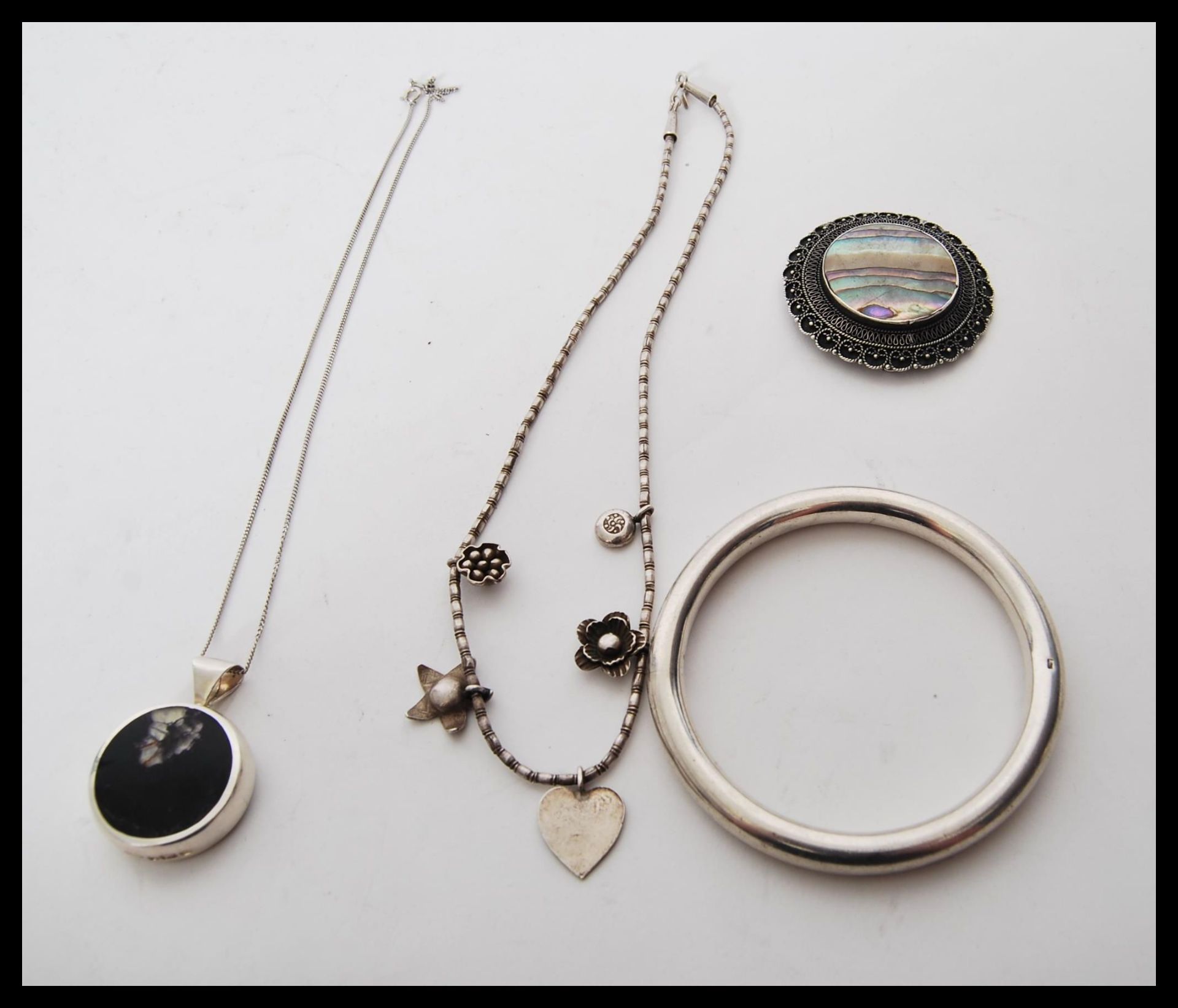 A selection of silver jewellery to include a stamped 925 silver bangle, a stamped 925 necklace of