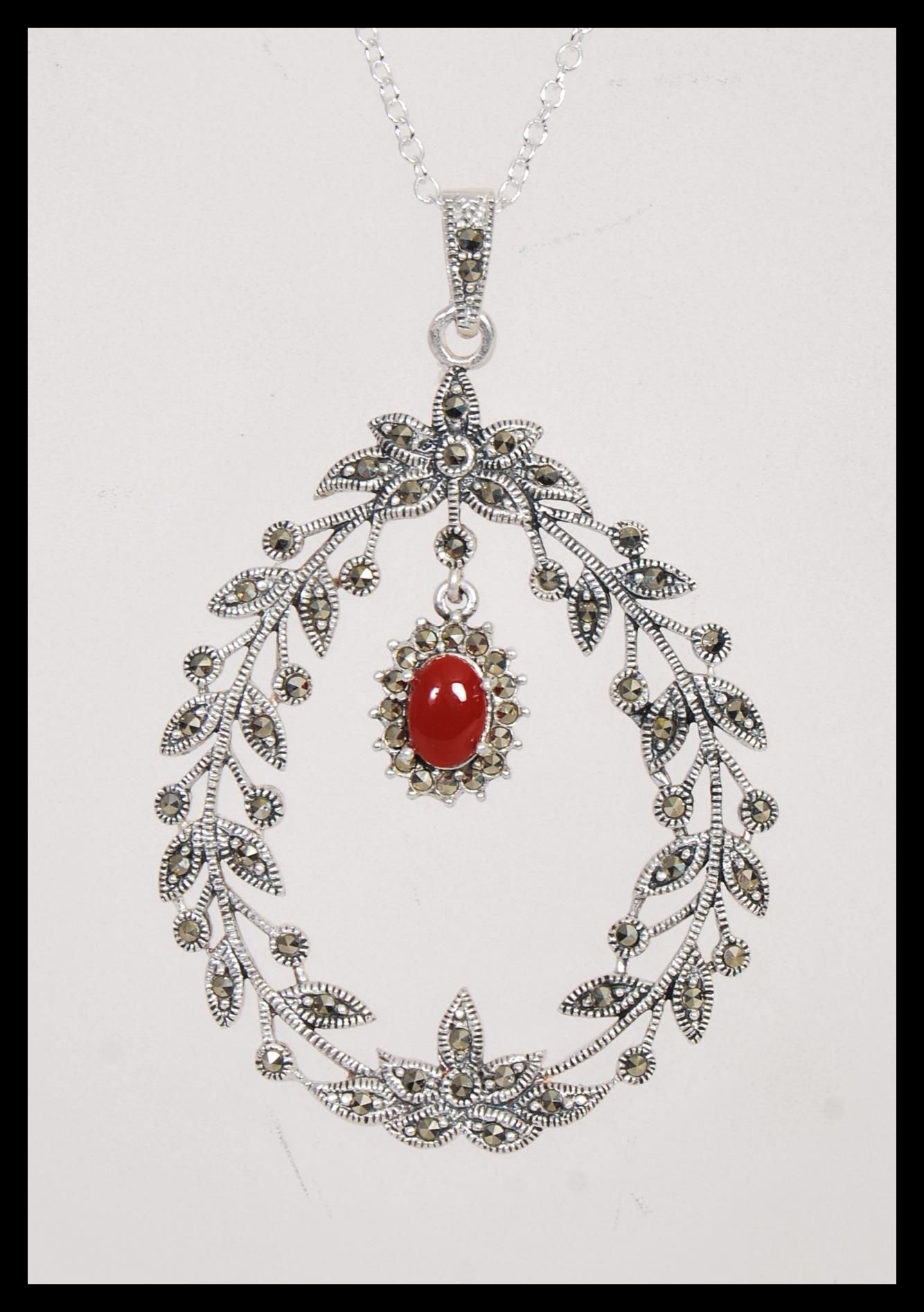 A stamped 925 silver necklace having a floral garland pendant set with marcasites and a coral