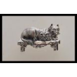 A stamped 925 silver brooch in the form of a cat sitting on a bench with a hinge pin to the verso.