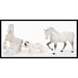 A collection of 20th century ceramic figurines to include a white Beswick horse having mottled