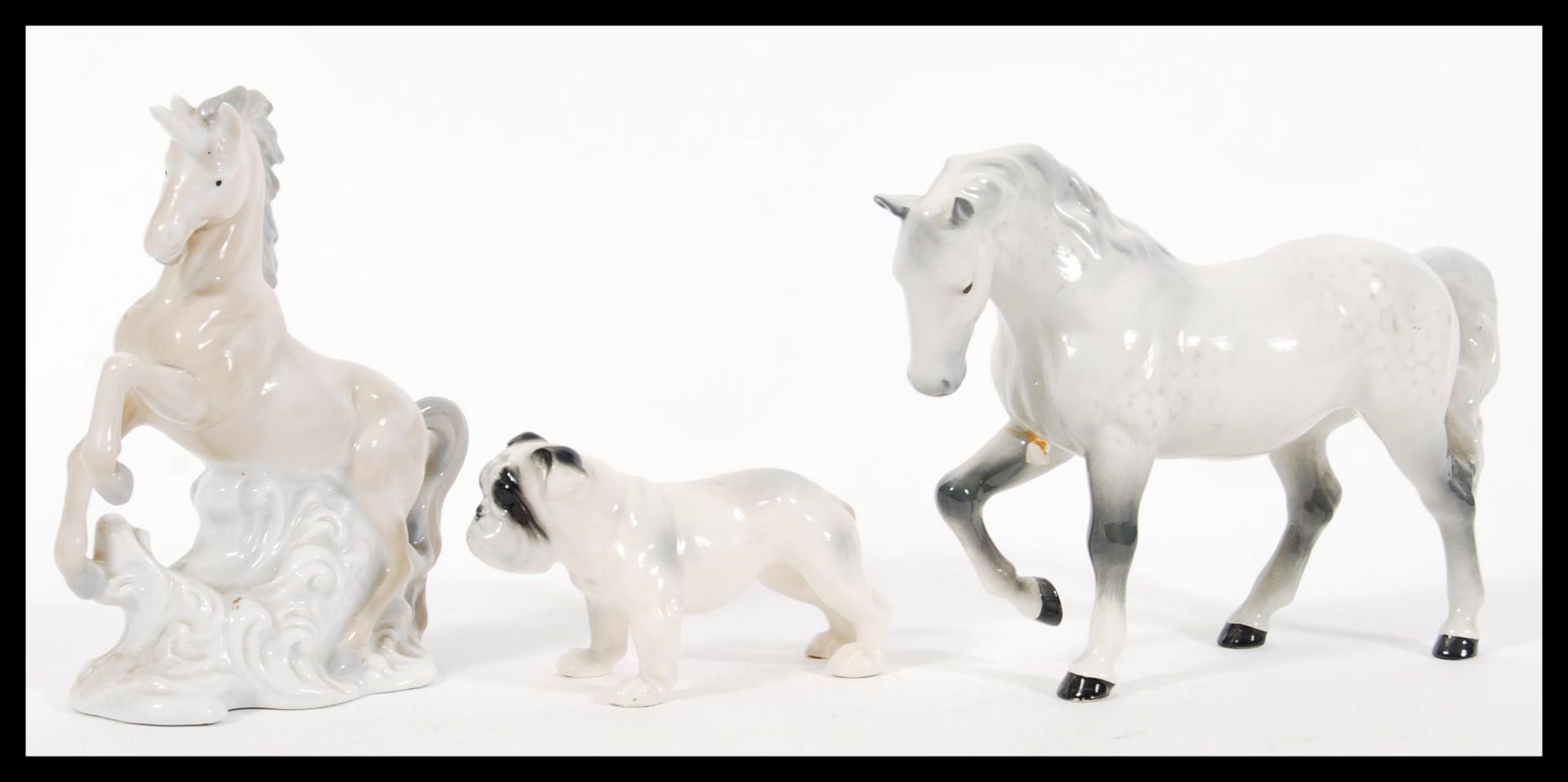 A collection of 20th century ceramic figurines to include a white Beswick horse having mottled