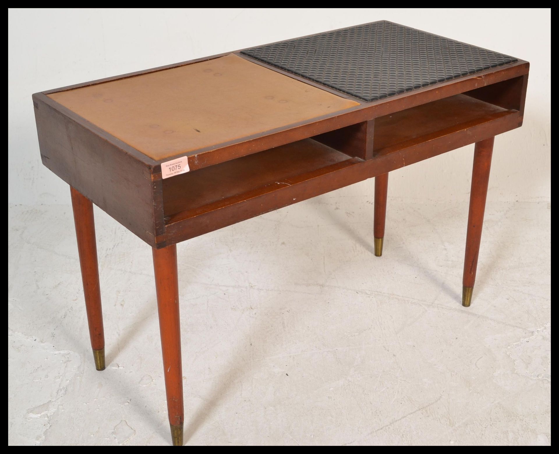 A vintage retro 20th Century teak wood telephone table raised on tapering legs with brass feet.