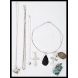 A selection of silver necklaces to include two crucifix pendants, a heart pendant necklace, a